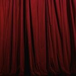 Czerwone teatralne kotary z eleganckimi upięciami na scenie