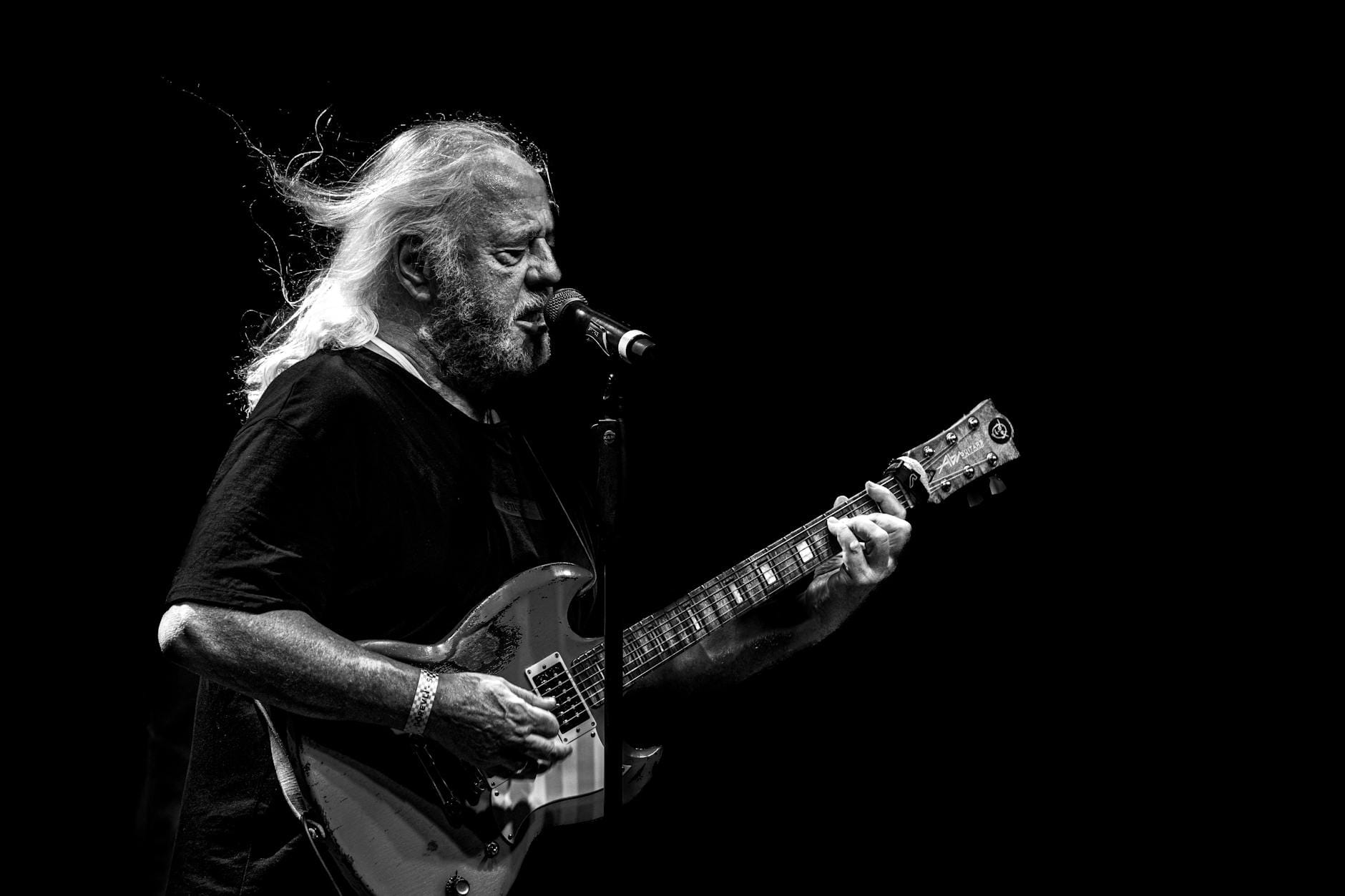 Gitarzysta na scenie w czarno-białym kadrze podczas występu