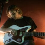 Gitarzysta elektryczny grający w barze przy ciepłym oświetleniu