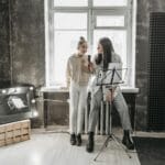 Nastolatek śpiewa z nauczycielem w nowoczesnym studiu muzycznym