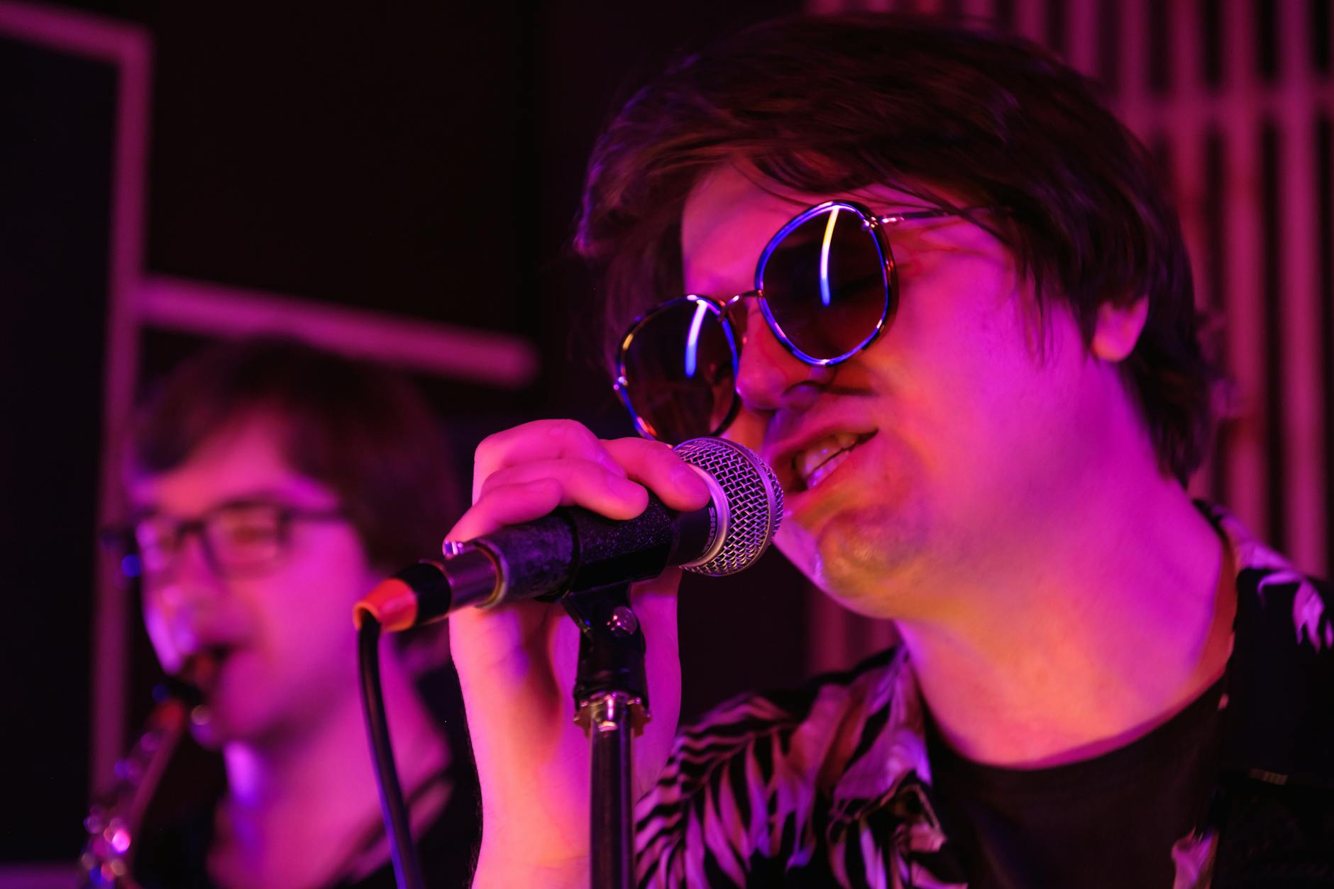 Rockowy wokalista w okularach przeciwsłonecznych na energetycznym koncercie