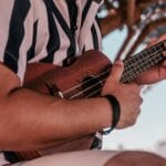 Dłonie szarpiące struny ukulele na świeżym powietrzu