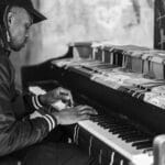 Mężczyzna gra na ulicznym fortepianie w czarno-białej tonacji zdjęcia