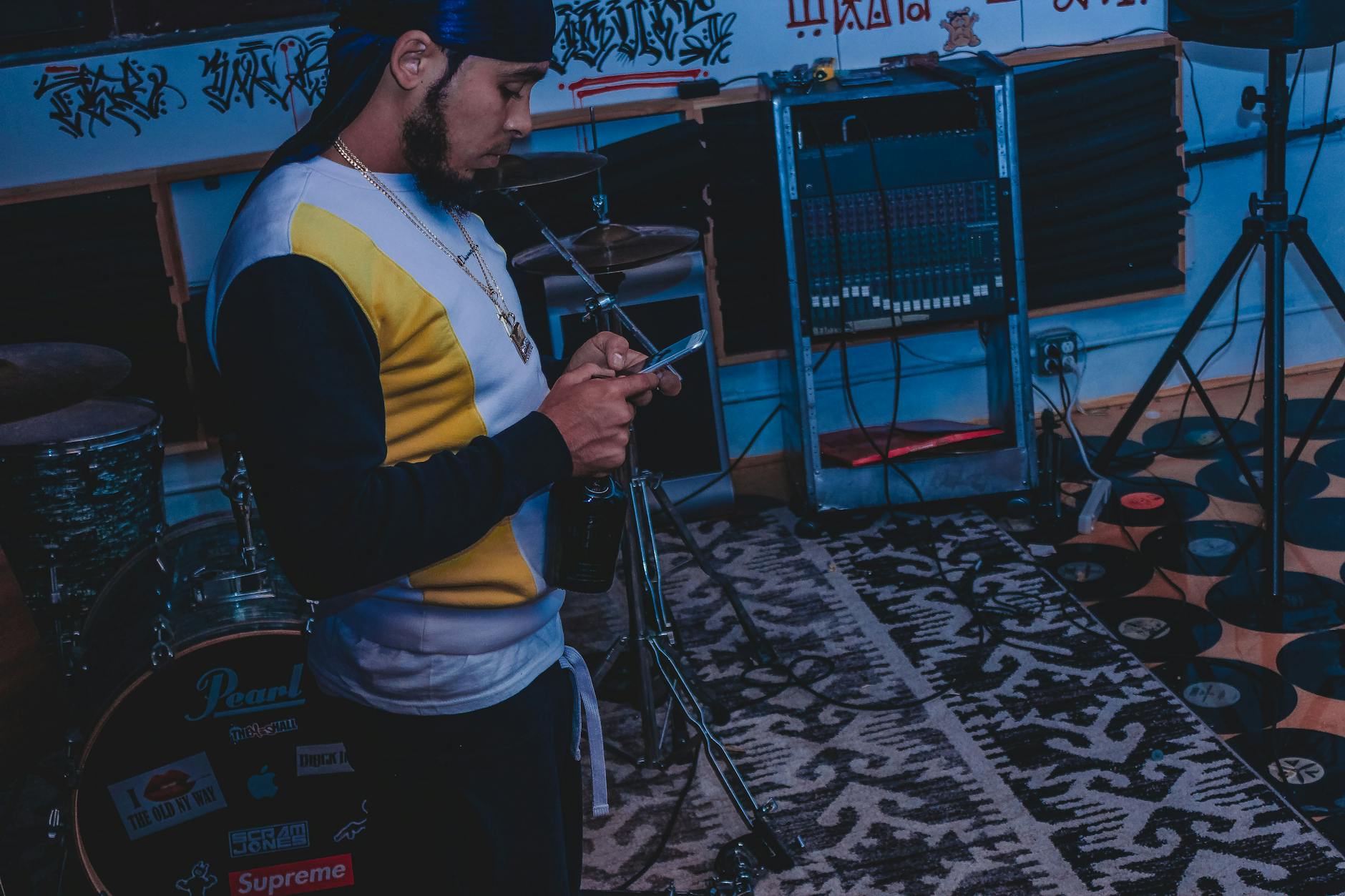 Muzyk w studiu nagrywa dźwięk smartfonem wśród instrumentów