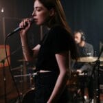 Wokalistka ćwiczy śpiew legato w studiu z zespołem