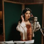 Wokalistka nagrywa ścieżkę dublowanego wokalu w studiu nagraniowym