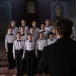 Chór chłopięcy śpiewający w kościele pod batutą dyrygenta