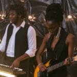 Duet grający na pianinie i gitarze elektrycznej w przytulnym wnętrzu