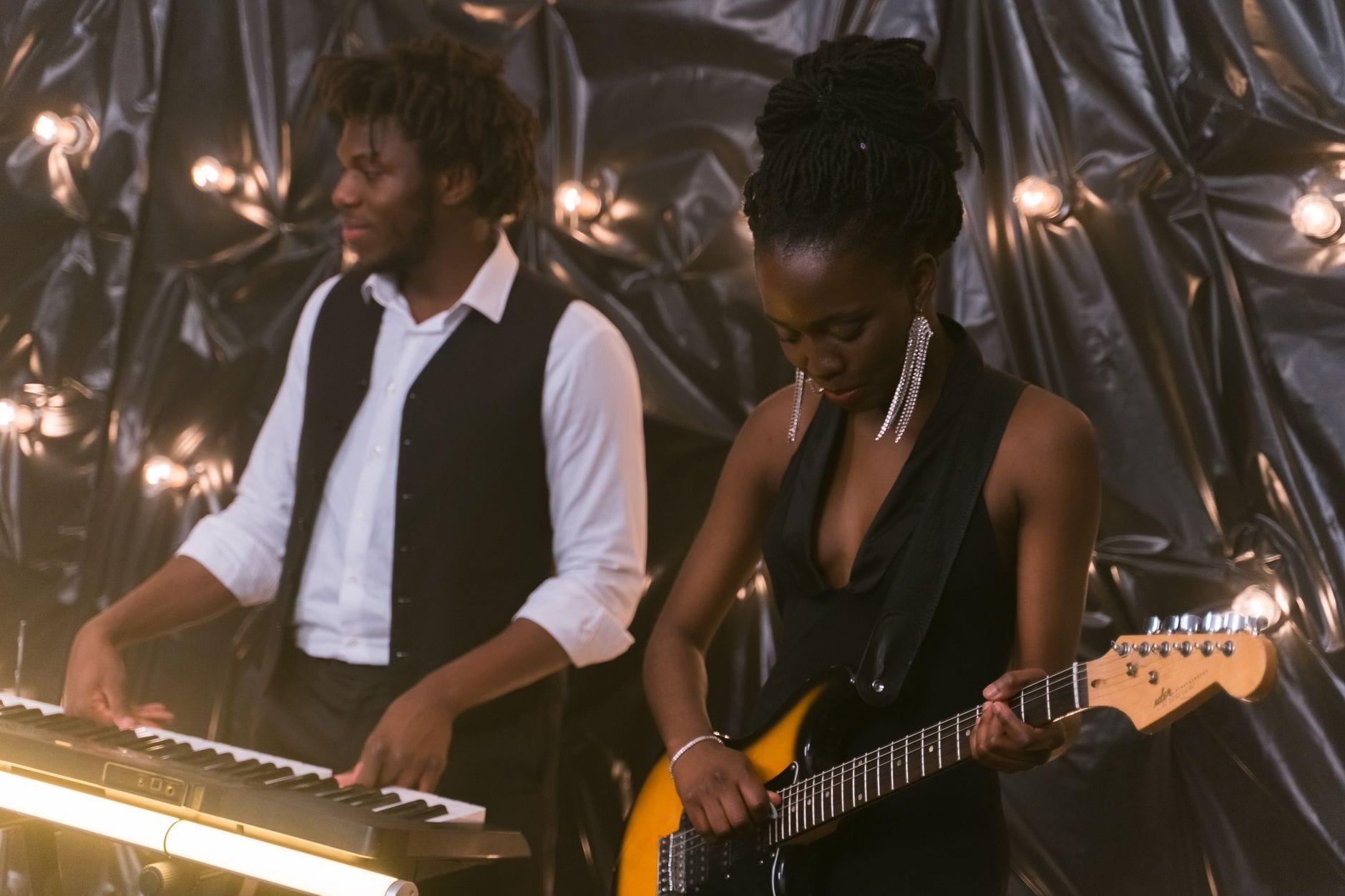 Jak budować trójdźwięki na pianinie i gitarze krok po kroku Duet grający na pianinie i gitarze elektrycznej w przytulnym wnętrzu