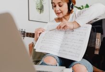 Darmowe programy do pisania i odtwarzania nut – MuseScore czy Finale Notepad? Kobieta prowadząca lekcję muzyki online z gitarą i nutami